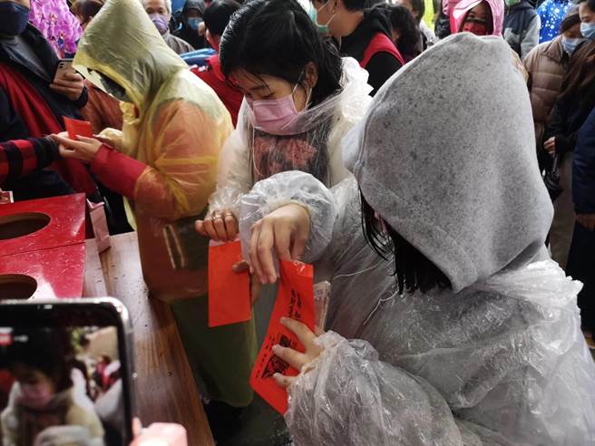 民眾抽出幸运红包，迫不及待打开。（庙方提供／王文吉台中传真）