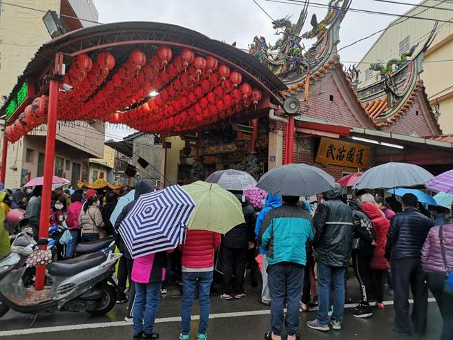 保安宫举办摸彩红包活动，民眾全身厚重大衣包紧紧，有的撑伞、有的穿雨衣到场试手气。（庙方提供／王文吉台中传真）