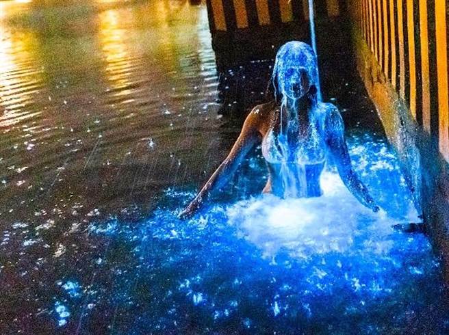 金门蓝眼泪大爆发，1名比基尼女子在新湖渔港岸边，以美人鱼般的婀娜身影从冰冷大海出水，抖落一身蓝点星光，摇曳出让人屏息的空灵美照。（简小姐提供）