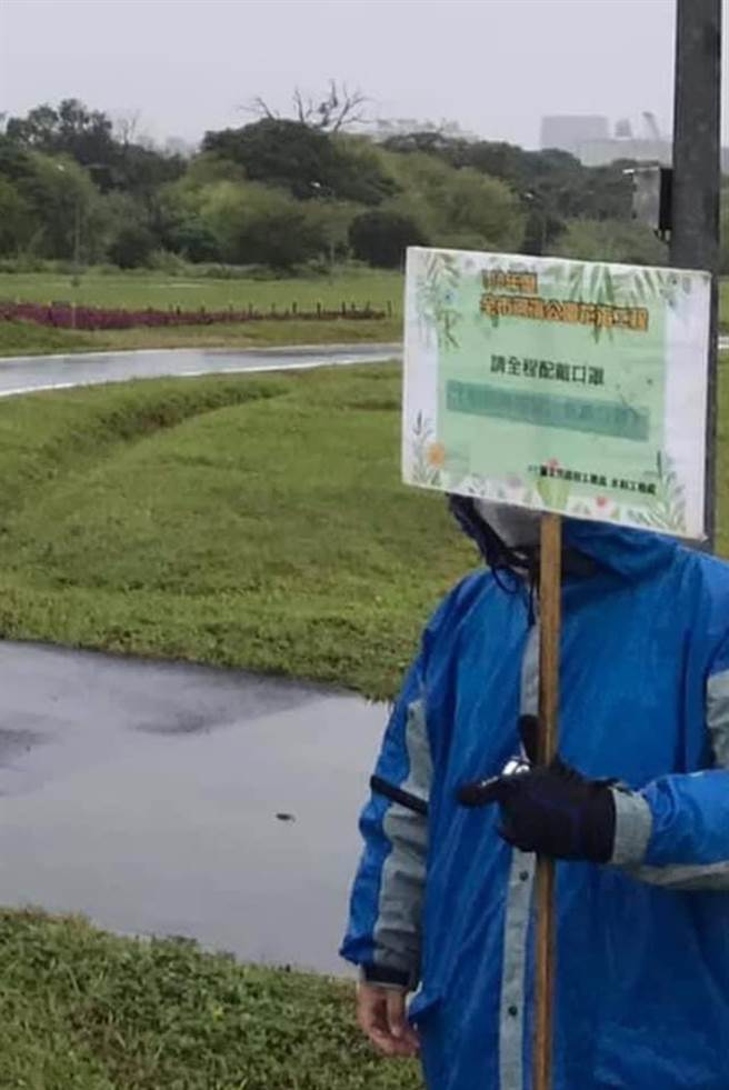 為了宣導防疫政策，員工在幾乎沒人經過的公園舉牌。（讀者「省道教授」提供）