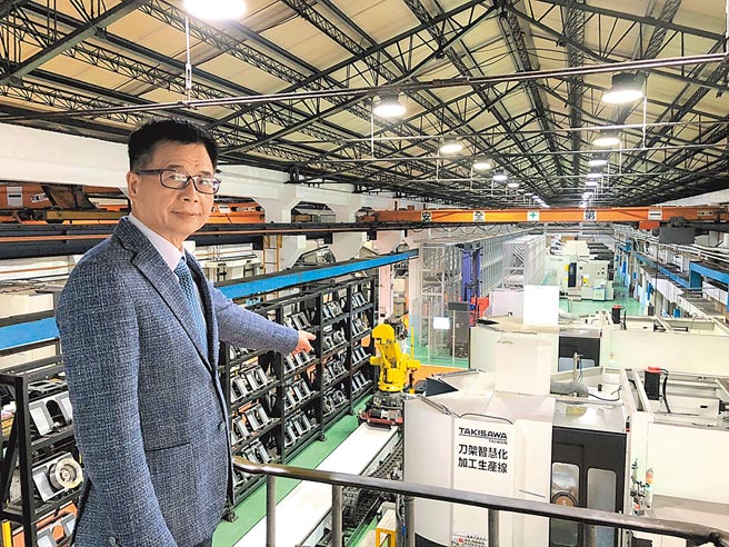 泷泽科董事总经理戴云锦与该公司建置完成的刀架智慧化加工生产线。图／庄富安
