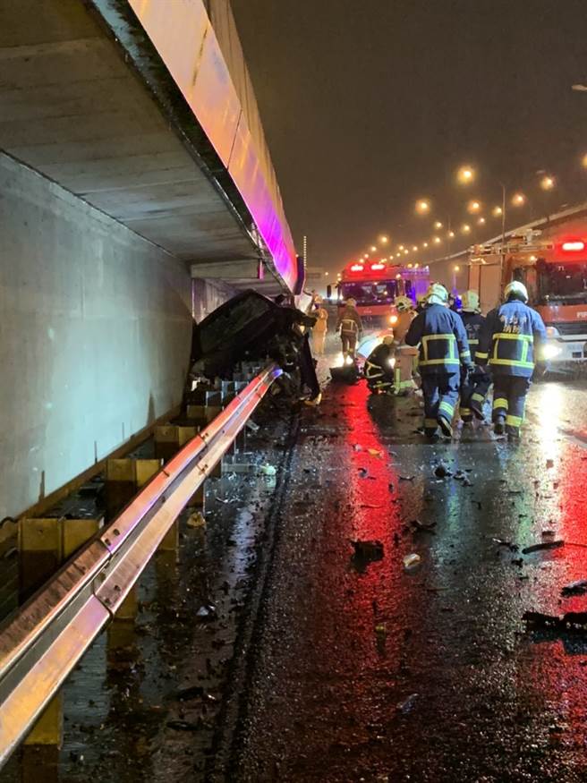 黑色BMW轿车骑在护栏上方，因撞击力道过猛，引擎及轮胎都喷飞。(记者爆料网提供)