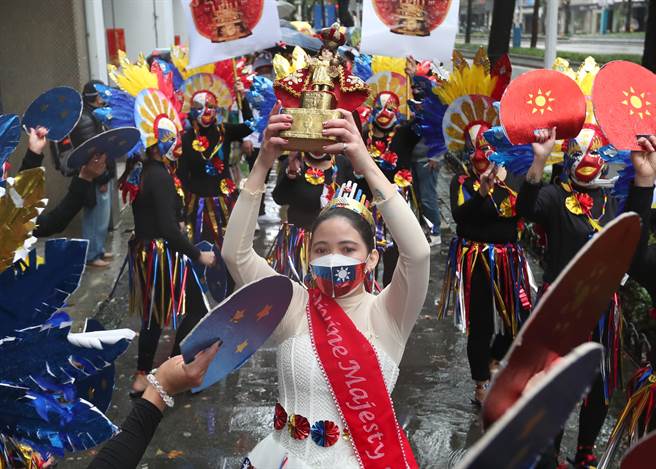尼拉經濟文化辦事處在台北街頭舉辦聖嬰嘉年華會遊街，以環保材質打扮的皇后捧著聖嬰像帶領隊伍前進，帶著有中華民國國旗圖案的口罩，象徵台菲深厚的情誼。（鄭任南攝）
