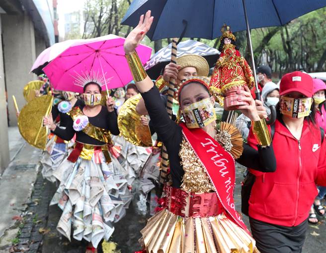 以環保材質打扮的皇后捧著聖嬰像帶領隊伍前進，向民眾打招呼。（鄭任南攝）