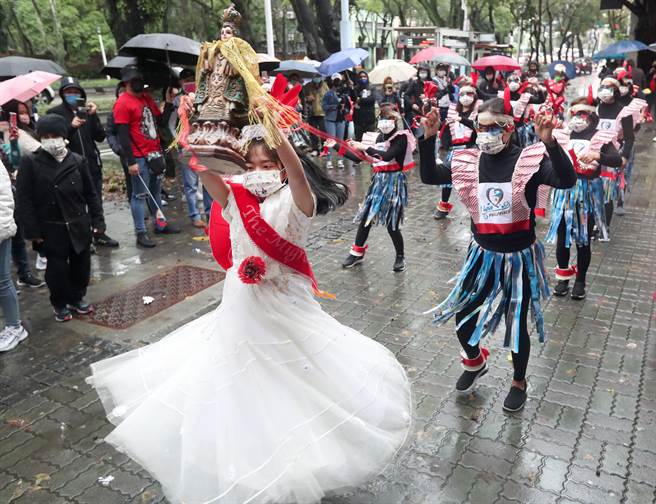 遊行隊伍以環保材質為裝扮素材，加上舞蹈來吸引民眾的目光。（鄭任南攝）