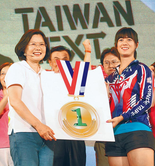 2011年，当时仍为民主进步党总统参选人的蔡英文出席高雄市国政演讲会，在高雄世运会夺得直排轮冠军的黄郁婷（右）上台将象徵第一名的金牌送给蔡英文（左）。（本报资料照片）