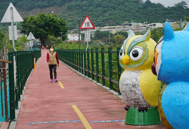 大里草湖溪自行车道健民里段，新增了数个色彩鲜艳的猫头鹰雕像，绿油油的山景下，非常亮眼。（黄国峰摄）