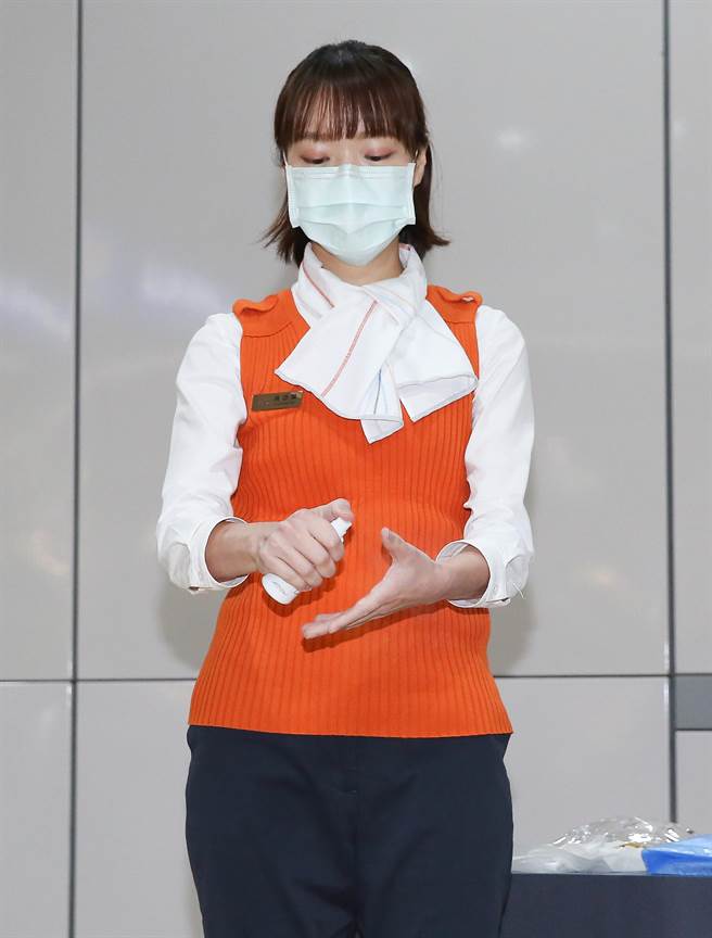 台灣高鐵公司落實防疫，首度公開列車組員演練課程，演練防護衣穿脫要點，先手部噴灑酒精。（陳俊吉攝）