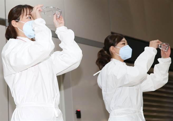 台灣高鐵公司落實防疫，首度公開列車組員演練課程，如果在列車上接獲通報有旅客疑似確診狀況，列車組員如何正確穿戴防護裝備，如拿起護目鏡並檢查有無破損。（陳俊吉攝）