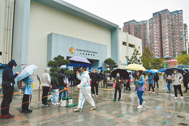 香港新冠疫情持续吃紧，特首林郑月娥宣布，将于3月推行全民强制筛检。图为香港民眾冒雨排队等候检测。（中新社）