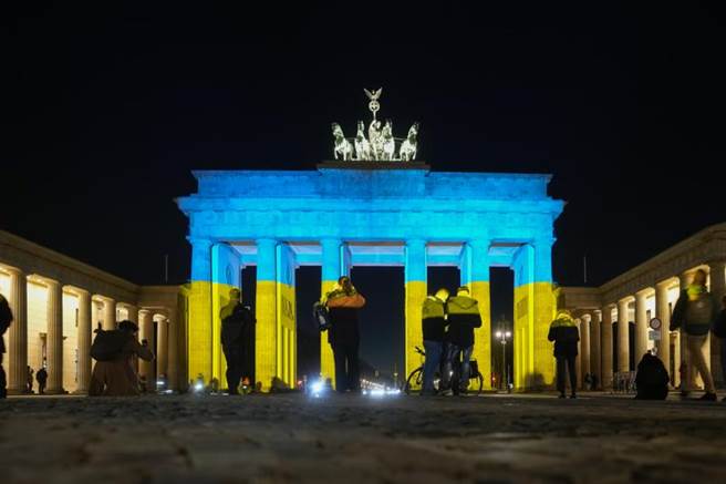德国首都柏林最知名地标布兰登堡大门（Brandenburg Gate），今晚把乌克兰国旗的蓝黄色投射在外墙上，以表达对乌国的支持。（美联社）