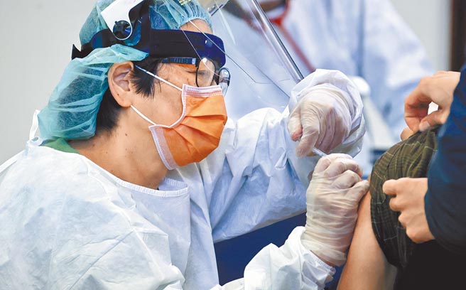 圖為第23期疫苗第3劑21日起至27日開放接種，醫護人員專注的替民眾注射疫苗。（羅永銘攝）