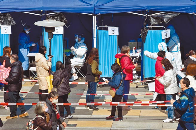 香港疫情持續緊張，昨天新增8798例確診，23日已有50人染疫死亡。圖為香港旺角街頭市民戴口罩出行。（新華社）