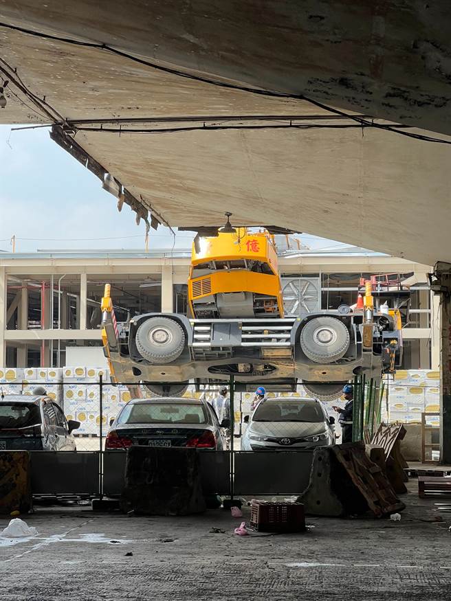 第一果菜批发中继市场工程发生工安事故，一辆吊车翻车卡在屋顶上。（第一果菜批发市场甲乙丙承销人自救会提供）
