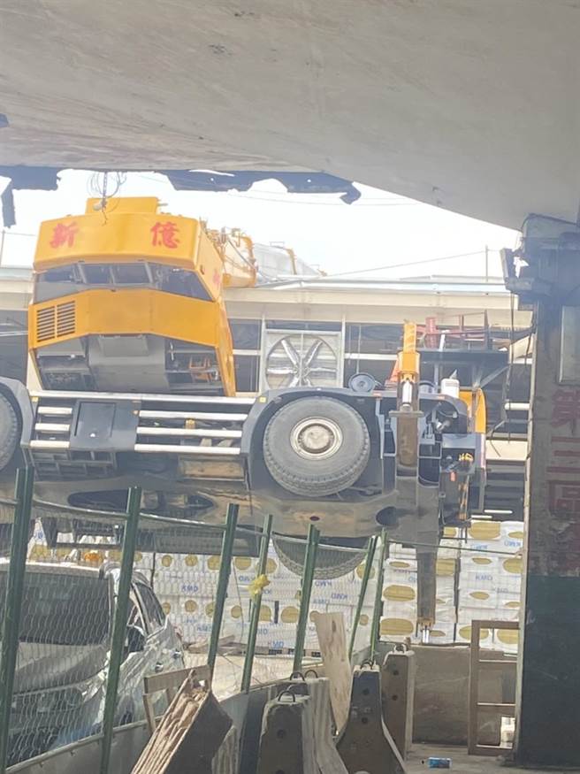 第一果菜批发中继市场工程发生工安事故，一辆吊车翻车卡在屋顶上。（第一市场自救会提供）