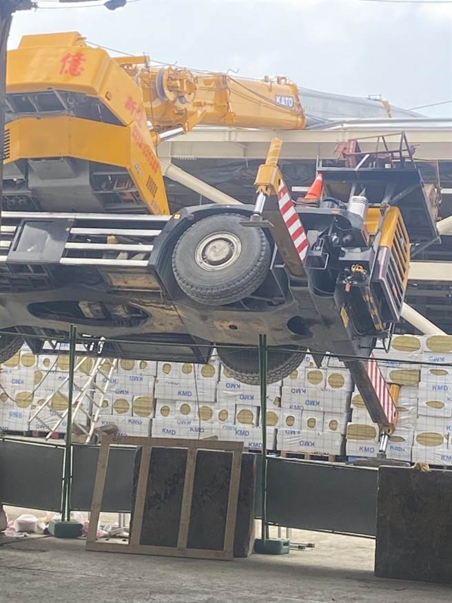 第一果菜批发中继市场工程发生工安事故，一辆吊车翻车卡在屋顶上。（第一市场自救会提供）