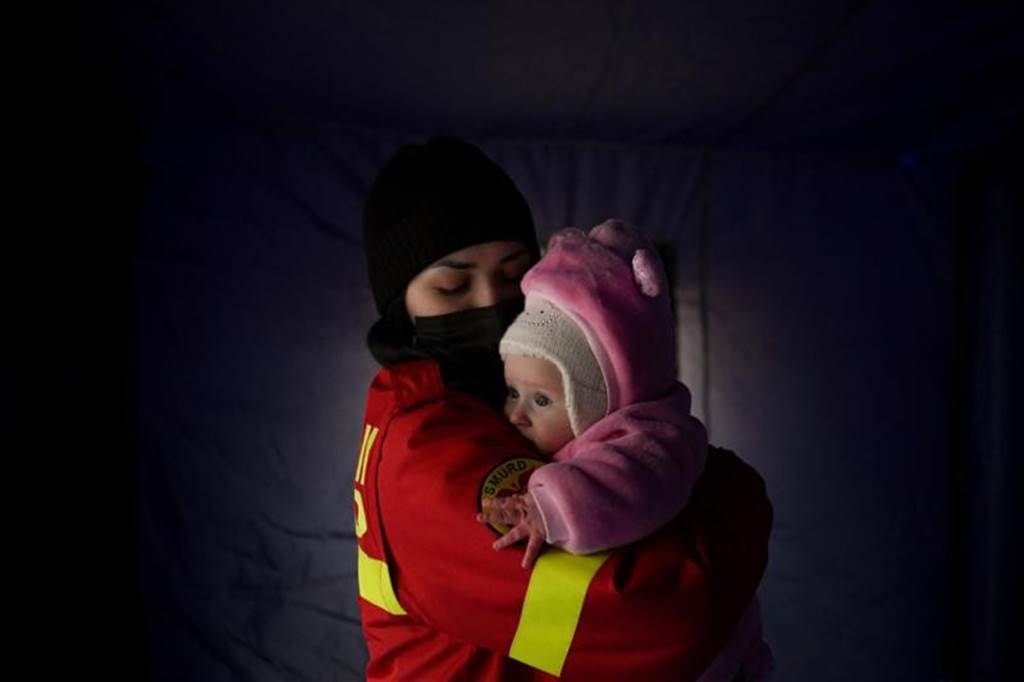 罗马尼亚边境检查站的工作人员正在安抚哭泣的乌克兰婴孩。（美联社）(photo:ChinaTimes)