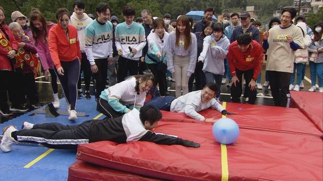 胡瓜（左）与马国毕示范游戏，结果慢两拍才扑倒在红垫上，手还离气球有一段距离。（民视提供）