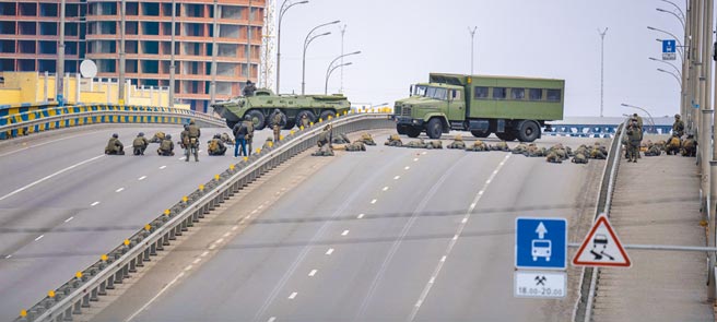 俄罗斯入侵乌克兰，台湾急着表态制裁俄罗斯，国关学者却认为，利弊得失恐很难估算。图为乌克兰士兵与军车驻守在基辅市区内的桥上。（美联社）