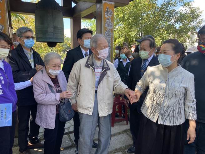 花莲县228关怀协会今上午在228和平广场举办追思音乐会，县长徐榛蔚牵着县内目前仅剩的受难者、高龄97岁的廖丙盛与其妻子，一起敲响3声和平钟。（罗亦晽摄）