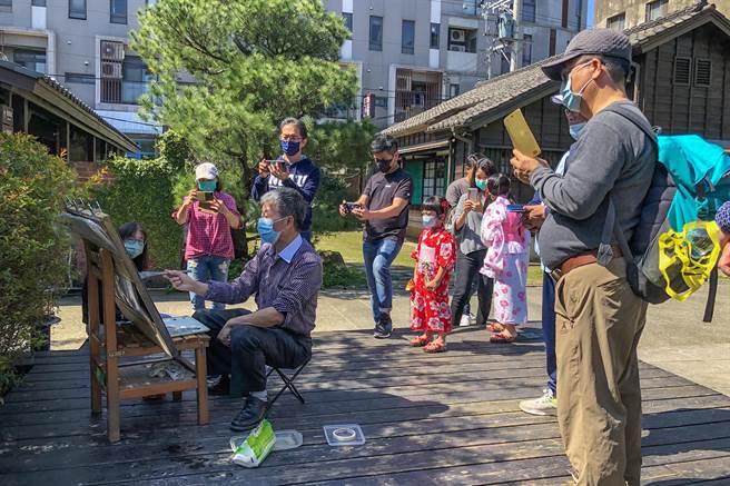 游客到萧如松艺术园区赏观水彩画家刘木林作画，有的拍照了解渲染技法，做文化知性之旅。（罗浚滨摄）