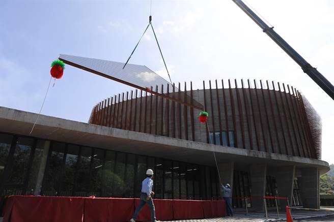 「台北氣象站合署辦公廳舍」工程外牆最後一片耐候鋼節能板正在用吊車進行安裝，完工後可望成為新店地區拍照打卡新地標。（新北市工務局提供）