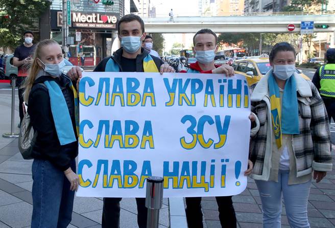 多位在台烏克蘭人和台灣公民團體再度前往莫斯科駐台北代表處外召開記者會，披著烏克蘭國旗高舉「支持烏克蘭」、「停止戰爭」等標語抗議俄羅斯入侵，要求俄羅斯立刻撤軍、停止侵略戰爭，有人比出不雅手勢抗議俄羅斯總統普丁發起戰爭。（趙雙傑攝）