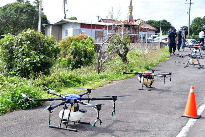 在民间科技业者的操控下，一架架载着友善环境生物防治资材黑疆菌的无人机接续升空，前往废耕果园上空喷洒。（谢琼云摄）