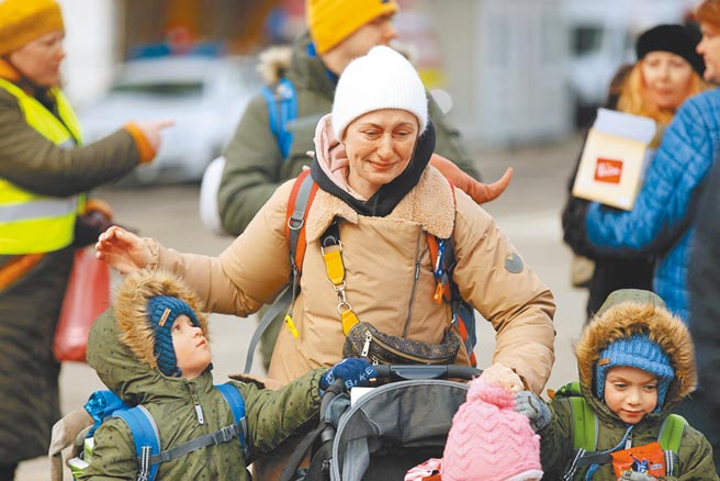 俄罗斯入侵乌克兰，一名妇女逃离到罗马尼亚边境后，在她的孩子身边哭泣。（路透）