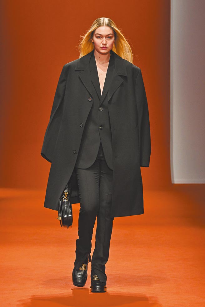 吉吉哈蒂德以黑色西裝外套、長褲搭配黑色大衣，為 TOD’Ｓ2022秋冬系列秀場拉開序幕。（TOD’S提供）