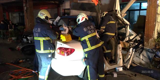 暗夜飞车衝入民宅骑楼，轿车撞到扭车变形，鹿港消防分队动用破坏器材救出女驾驶。（彰化县消防局提供／吴敏菁彰化传真）