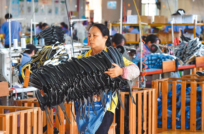 全球疫情的起伏反覆也让外需市场面临不确定性，原物料、大宗商品的供给仍未恢復正常，让供应链瓶颈预计短期难以缓解。图为福建的工厂工人搬运棒球手套。（中新社）