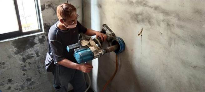 （芦洲「海砂屋一条街」继去年完成整合第一笔都更案之后，住都中心也展开第二案重建之路，日前已展开住户家中及楼梯间的钻孔取样作业。图／新北市住都中心提供）