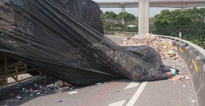 桃園市45歲廖姓男子今天11時25分，駕駛聯結車載運廢紙從幼獅交流道前往新屋，但行經北向66系統從平鎮系統出北往西匝道時，過彎卻將廢紙撒落於匝道。（警方提供）