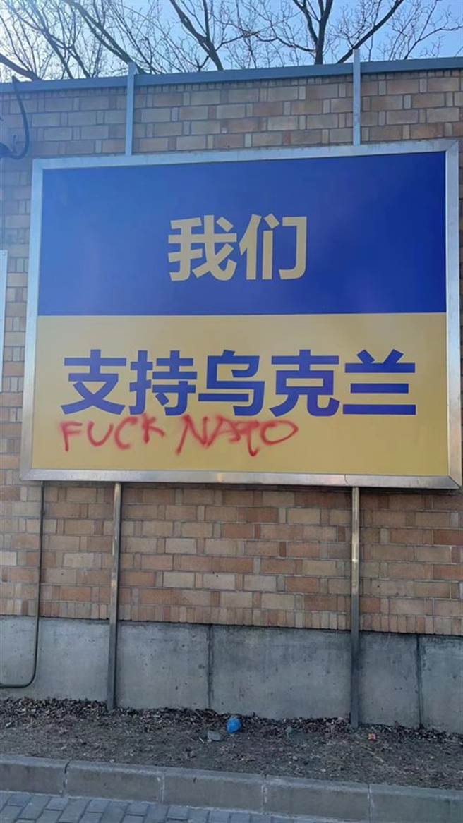 加拿大駐中國大使館在外圍牆面上的燈箱呈現「我們支持烏克蘭」、「我們和烏克蘭在一起」等文字，昨天被發現其中一面燈箱看板遭噴漆不雅文字。（圖／推特@FightDisinform4）