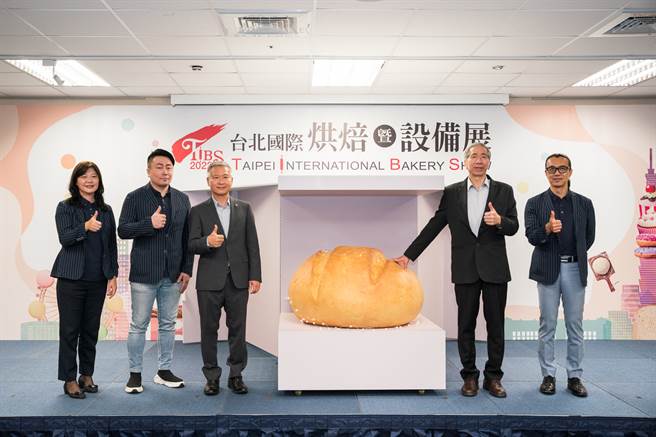 台北国际烘焙暨设备展副主委赖樱暖(由左至右)、侯景中、展昭国际企业姚晤毅副总经理、台北市糕饼商业同业公会周正训理事长、台北市糕饼商业同业公会高垂琮名誉理事长共同开箱疗癒巨型麵包。(戴志扬翻摄)