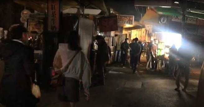 高雄今天入夜後，多個行政區仍未恢復供電，民眾摸黑逛夜市。（翻攝影片）