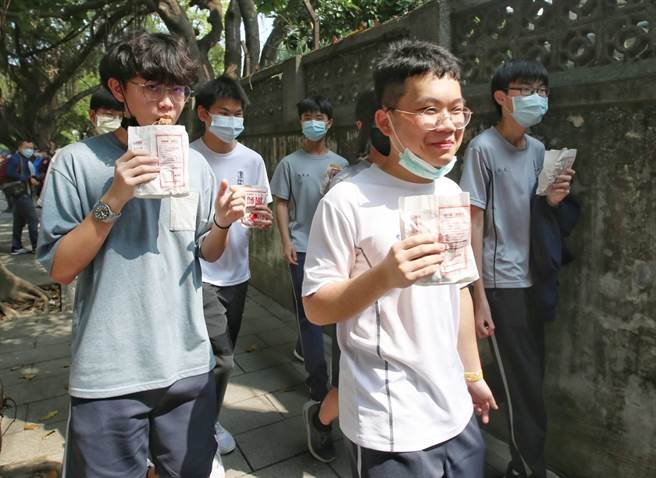 針對全台無預警發生大停電，而經濟部長王美花曾與鴻海創辦人郭台銘對賭「缺電就請吃雞排」等言論，國民黨立委林為洲4日特別在經濟部門口發放303份雞排，諷刺王美花，排隊的學生們開心吃著剛領到的雞排。（趙雙傑攝）