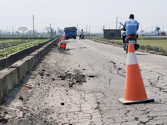 已破碎不堪的路面擺放三角錐，阻止大車進入，但經常被大車司機移走。（周麗蘭攝）