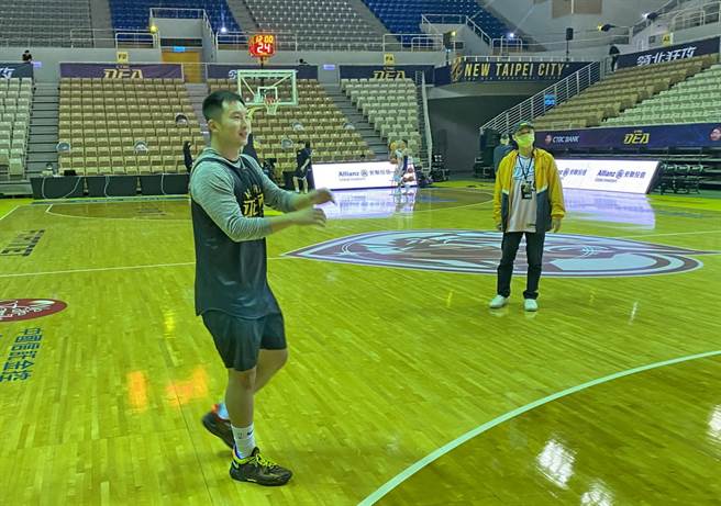 场上灯光都还没打开，赖国维已经在赛前进行练投热身了。(黄及人摄)