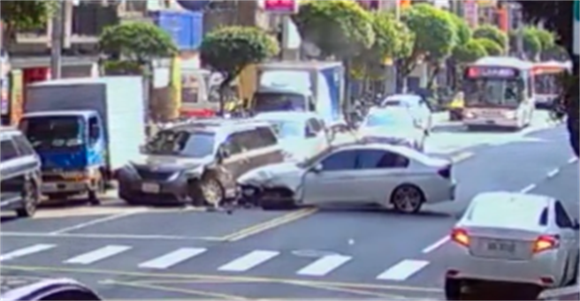永和1辆BMW白车在行经路口时突然从内车道直接往对向车衝去，猛烈撞上对向轿车，之后打横在路面，BMW的左车头几乎全毁、轮胎喷飞。（翻摄自记者爆料网）