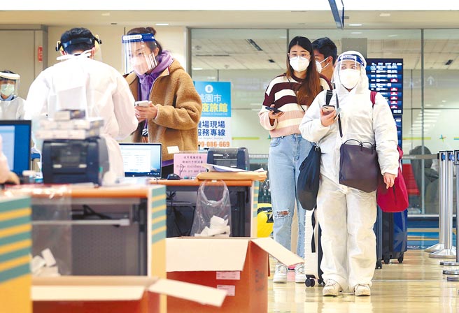 台北市某防疫旅館日前傳4人確診，感染源為一名香港入境住客。圖為在桃園機場第二航廈的入境管制區內，旅客排隊查驗入境檢疫憑證。（范揚光攝）