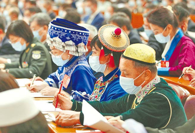 大陆全国政协十三届第五次会议4日下午3时开幕，代表大陆正式进入全国两会时间。图为开幕式上，少数民族政协委员仔细看报告。（新华社）