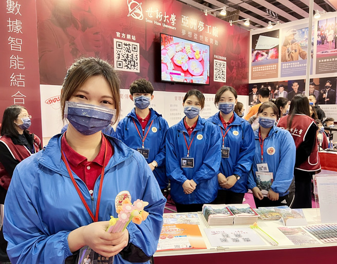 2022大学博览会展摊上拿着世新大学花朵造型笔发送学子，你愿意嫁给世新？（王雅芬摄影）