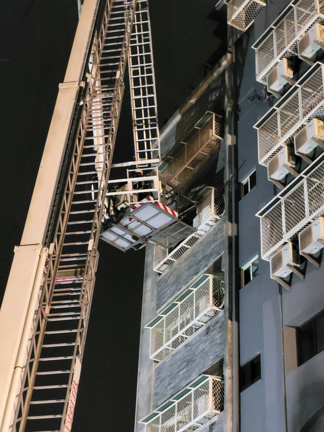 台中市兴中街6日发生大火，抢救过程中有三名受困民眾站在高楼层外的窗台，其中一人坠落，幸有路旁轿车缓衝，送医后无生命危险，另外2人由云梯车救下，消防队一共在火场救出8人，其中一名六十五岁妇人在今晚六点多被找到时因躲在三楼浴室中，已无生命迹象。（陈界良摄）