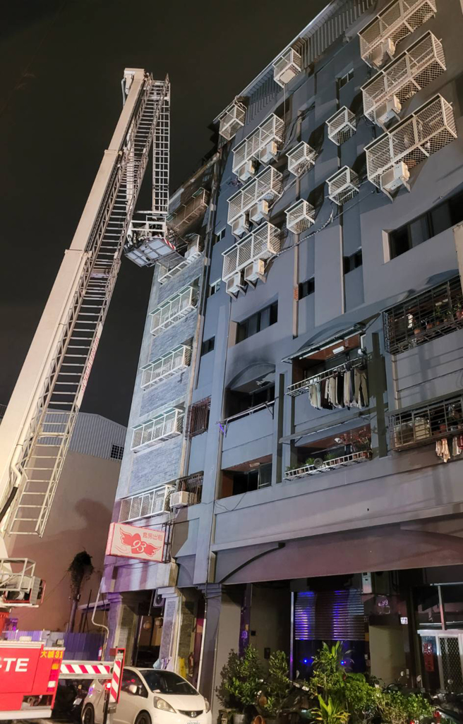 台中市兴中街6日发生大火，抢救过程中有三名受困民眾站在高楼层外的窗台，其中一人坠落，幸有路旁轿车缓衝，送医后无生命危险，另外2人由云梯车救下，消防队一共在火场救出8人，其中一名六十五岁妇人在今晚六点多被找到时因躲在三楼浴室中，已无生命迹象。（陈界良摄）