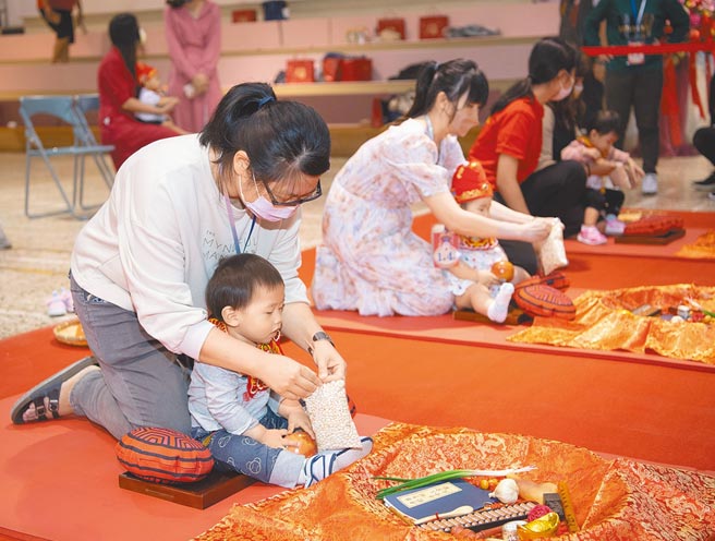嘉义市「城隍佑民，文昌护子」公益古礼抓周活动5日登场，40名萌娃穿戴状元帽及平安虎围兜体验抓周乐趣。（吕妍庭摄）