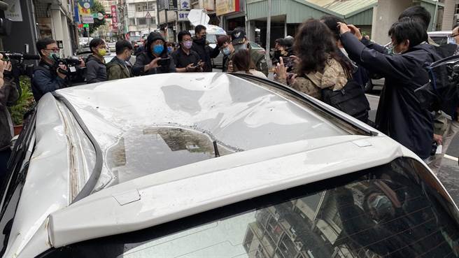 台中市兴中街民宅大火，有住户跳楼逃生，掉落在停放在楼下路旁的白色小轿车，车主杨小姐到场探视爱车。（陈淑芬摄）