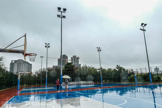 竹北高铁特区世兴篮球场照明电杆的电缆线遭窃， 竹北市民代表蔡蕥鍹（左）会勘希望公所儘速修復，设监视器防窃，并盖风雨球场，让民眾雨天也能运动。（罗浚滨摄）