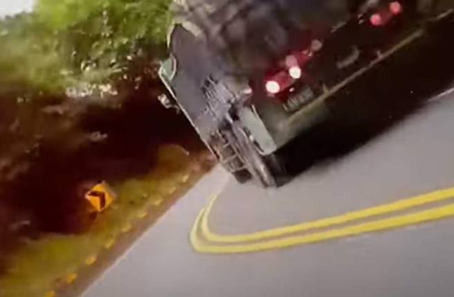 騎士路面翻滾，對向大卡車擦身而過。（翻攝臉書《●【爆料公社二社】●》影片）